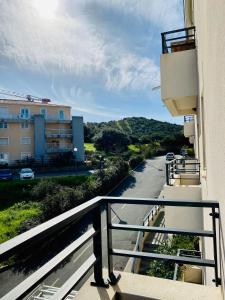 a balcony of a building with a view of a street at Studio tout confort en centre ville in Propriano