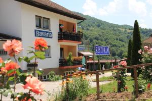 a building with flowers in front of a mountain at Motel Bavaria in Foča