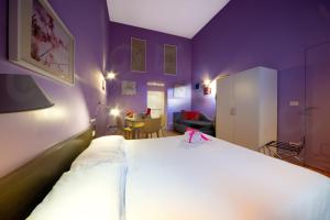 1 dormitorio con cama blanca y paredes moradas en Ripetta 25 Prestige Rooms en Roma