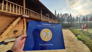 a person holding a sign in front of a building at Toong homestay in Ha Giang +29 photos