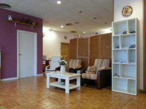 a living room with a couch and a table and chairs at Pensión Pamplonabeds in Pamplona