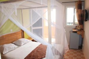 a bedroom with a bed with a mosquito net at Africa 6 Plage in Somone