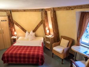 a bedroom with a bed and a chair in a room at Gästehaus zur ehemaligen Mehlwaage wohnen und genießen in Bamberg +13 photos