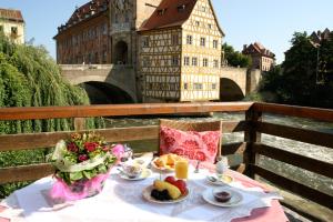 uma mesa com pratos de comida no topo de uma ponte em Hotel Brudermühle em Bamberg