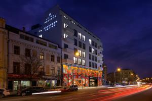 a building on a city street at night at Hotel Passage in Brno