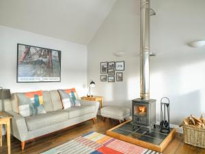 a living room with a couch and a stove at Signal Box in Newtonmore