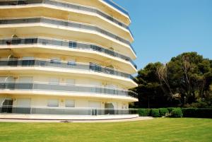 an apartment building with a lawn in front of it at MEDES PLATJA BX-1 in L'Estartit