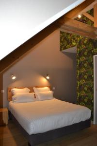 A bed or beds in a room at Logis Auberge de Pont Calleck