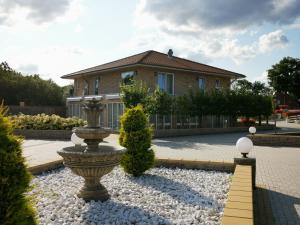 een huis met een fontein in het midden van een tuin bij Hotel Garni Am Lindenhof Bunde in Bunde