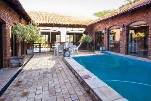 a house with a swimming pool and a patio at Stephan's Guest House in Port Shepstone