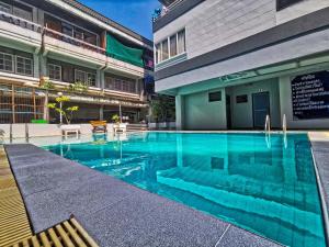 a swimming pool in front of a building at Hagone-Condotel Pattaya in Pattaya South