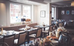 a dining room with tables and chairs and a window at Hotel-Restaurant Osterather Hof in Meerbusch
