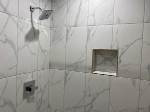 baño blanco con espejo y ducha en Tweetys 9 Diamond Inn, en Houston