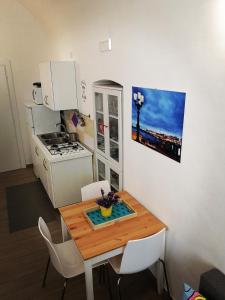 a small kitchen with a wooden table and white appliances at white house in Bari