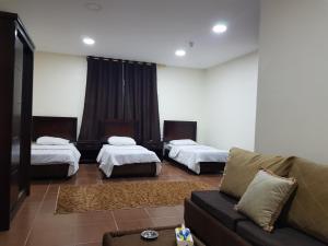 ein Wohnzimmer mit 2 Betten und einem Sofa in der Unterkunft Siveen Hotel in Amman