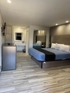 a bedroom with a large bed and a kitchen at Tweetys 9 Diamond Inn in Houston