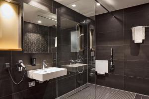 ein Badezimmer mit zwei Waschbecken und einer Dusche in der Unterkunft Hotel im LESKANPark in Köln