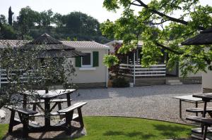 a patio with picnic tables and a house at Agriturismo & Agricamping Serena in Pastrengo