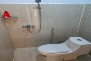 a bathroom with a toilet and a shower at RedDoorz near RSUD Kota Luwuk in Luwuk