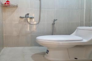 a bathroom with a toilet and a shower at RedDoorz near RSUD Kota Luwuk in Luwuk