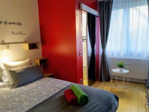 um quarto com uma cama e uma parede vermelha em ZagrebFun em Zagreb