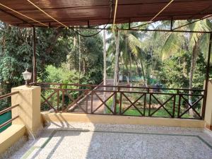 a balcony with a wooden fence and trees at Kamal 2 Bedroom Bungalow With Terrace in Kīhīm