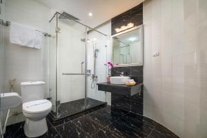 a bathroom with a shower and a toilet and a sink at Hanoi Lotus Boutique Hotel in Hanoi