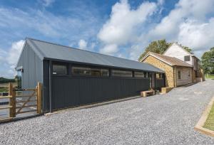 a house with a black garage and a fence at Hoods in Bridport