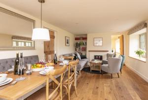 a dining room and living room with a table and chairs at Evergreen in Bransgore