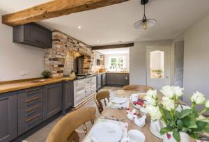 cocina con mesa de madera y comedor en Lanes End Cottage en Dorchester
