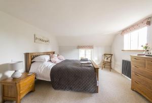 1 dormitorio con 1 cama con mesa y vestidor en Lanes End Cottage en Dorchester