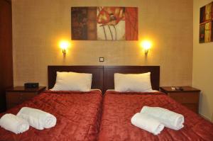 a bedroom with a red bed with two pillows on it at Corfu Studios Stavroula - San George Apartments in Agios Georgios Pagon