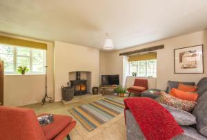 sala de estar con sofá y chimenea en Horsehill Cottage, en Stoke Abbott