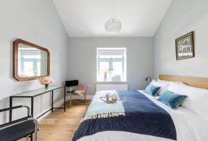 - une chambre avec un grand lit et un miroir dans l'établissement Stapleford Farm Cottages, à Beaminster