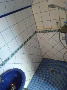 La salle de bains est pourvue d'un lavabo bleu et de carrelage. dans l'établissement Chambres d'hôtes du Port aux Cerises, à Vigneux-sur-Seine