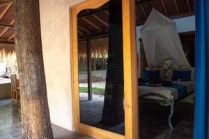 a mirror reflection of a bed in a room at Jati Village, Party Hostel and Bungalows in Gili Trawangan