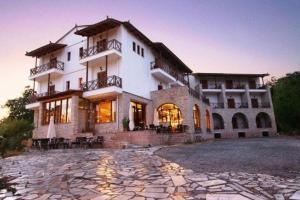 a large house with a stone driveway in front of it at Mont Helmos Hotel in Klitoria