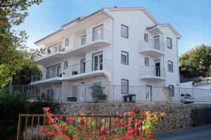 a white building with flowers in front of it at Villa Dragi with Pool, Sauna, & Whirlpool in Opatija