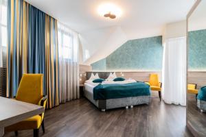 - une chambre avec un lit, une table et des chaises dans l'établissement Hotel Villa Groff, à Ora