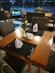 a wooden table with pink napkins on top of it at Parkside Plaza Muscat in Muscat