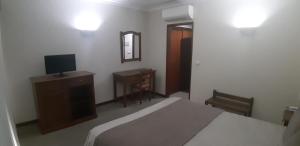Uma TV ou centro de entretenimento em Hotel Santa Maria