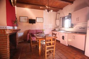 cocina con mesa y sillas en una habitación en Las Casitas en Higuera de la Sierra