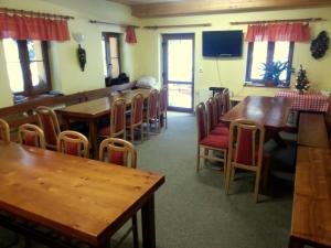 Un comedor con mesas y sillas de madera. en Penzion ANTONIE, en Malá Morávka