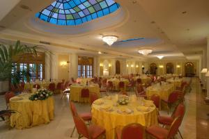 un salón de banquetes con mesas y sillas y techo de cristal en Ambasciatori Place Hotel, en Fiuggi