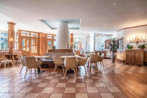 a dining room with tables and chairs in a building at Sporting Aparthotel in San Martino di Castrozza