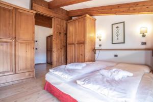 a bedroom with two beds and wooden walls at Sporting Aparthotel in San Martino di Castrozza +32 photos