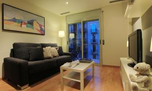 a living room with a couch and a table at Alguera Apartments Industria in Barcelona