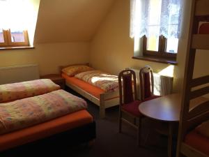 una habitación con dos camas y una mesa y sillas en Penzion ANTONIE, en Malá Morávka 72 fotos más