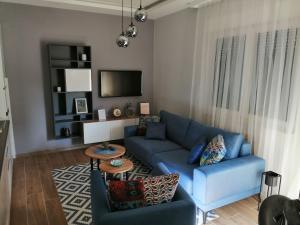 sala de estar con sofá azul y TV en Stefan Apartment en Bijeljina
