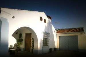 un edificio blanco con puerta y garaje en Casa Rural LA CASA DEL AGUA MÉRIDA, en La Garrovilla